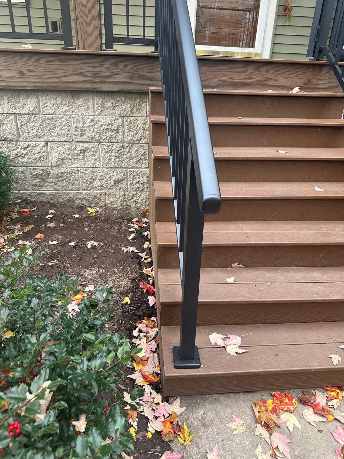Black metal porch railing installed on composite steps