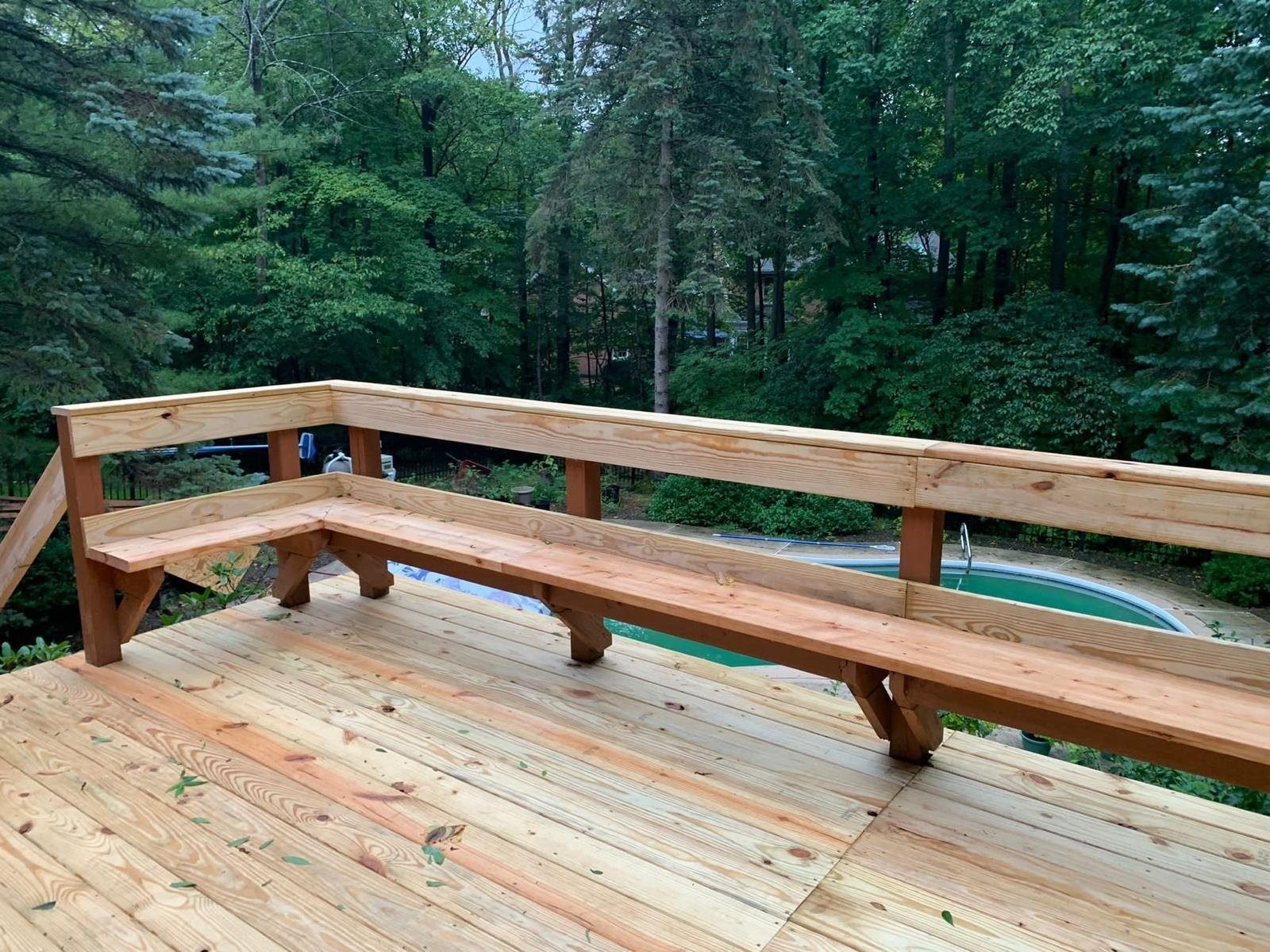 Custom deck railing with built-in bench seating overlooking a pool
