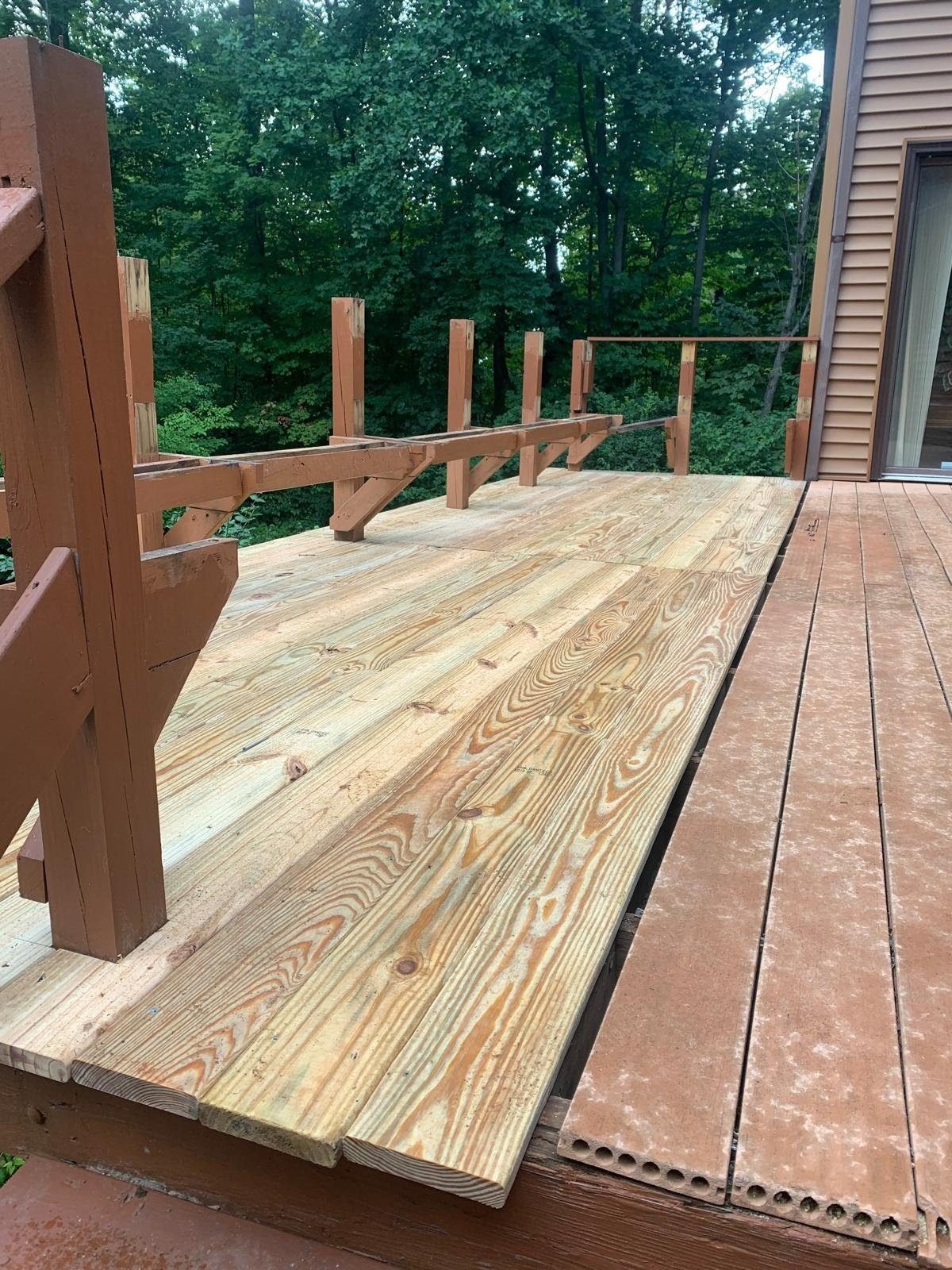 New deck boards installed next to old boards being removed during a rebuild