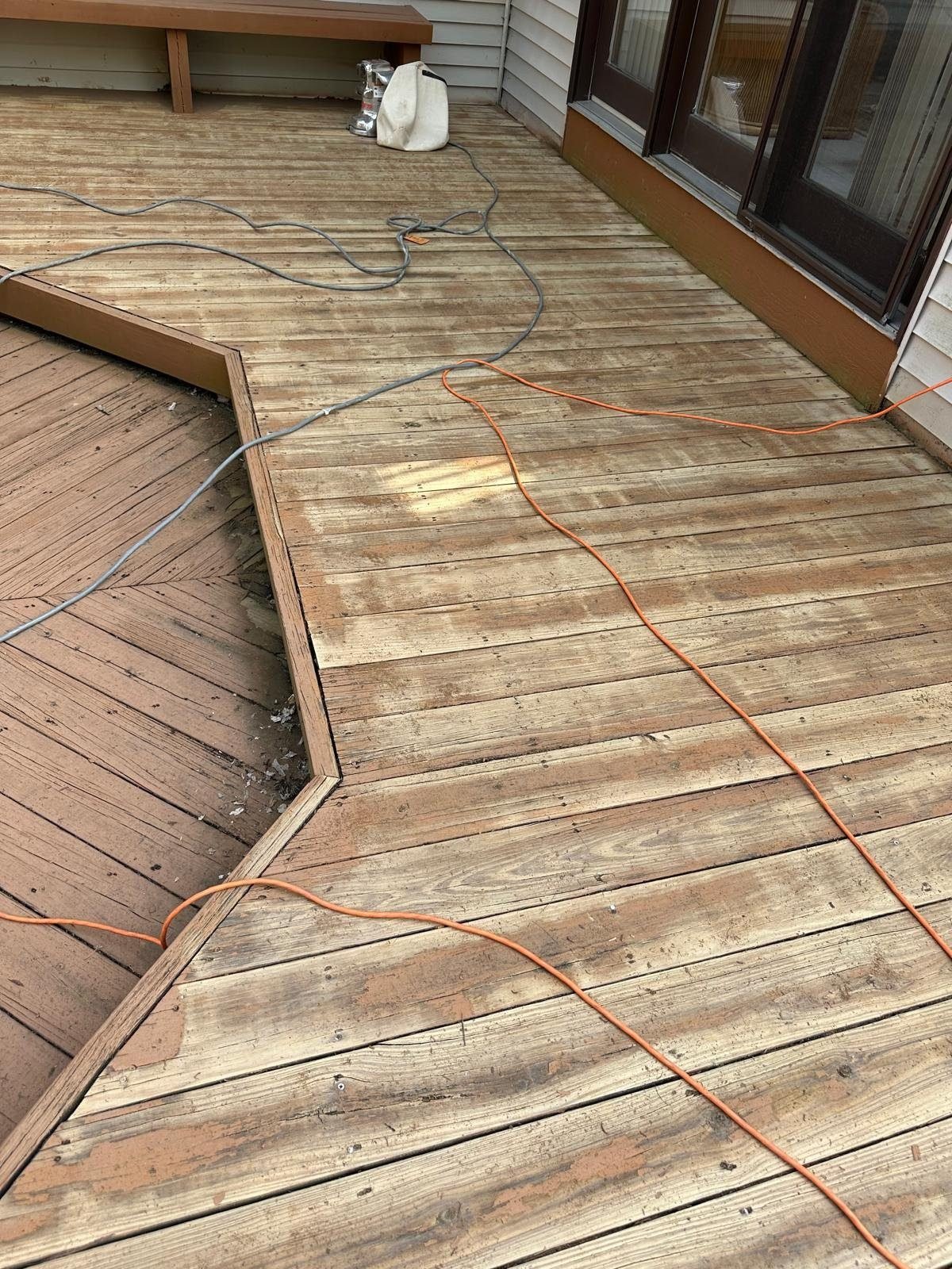 Weathered deck being power washed and prepped for restoration