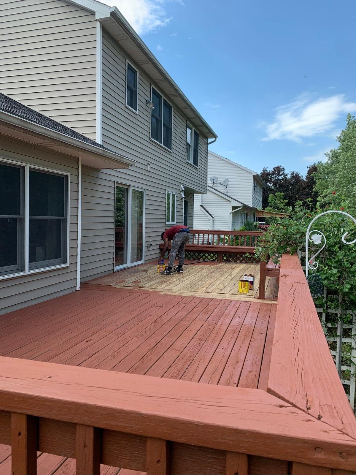 Crew applying stain to a deck