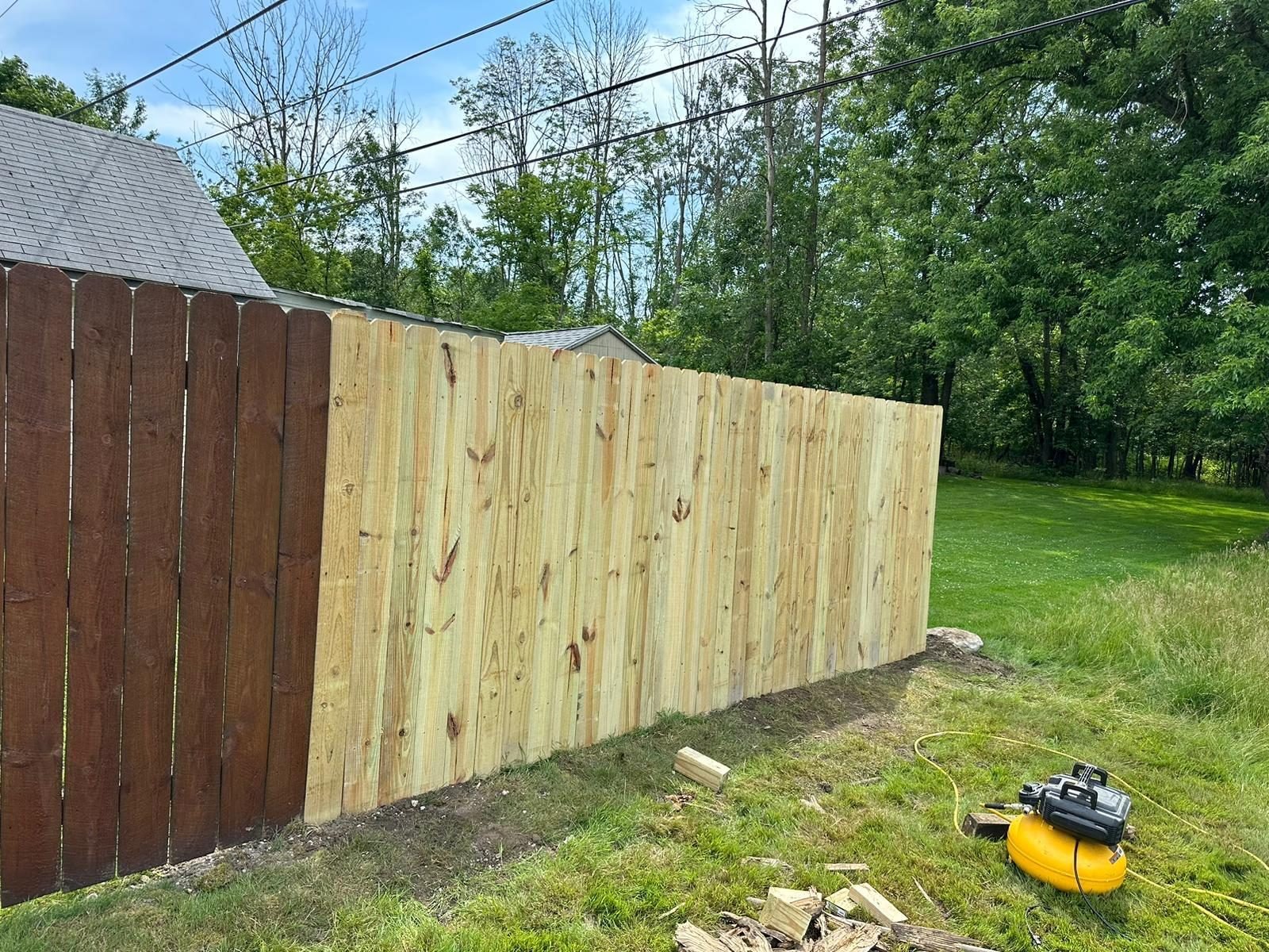 Fence repair showing a newly replaced panel section