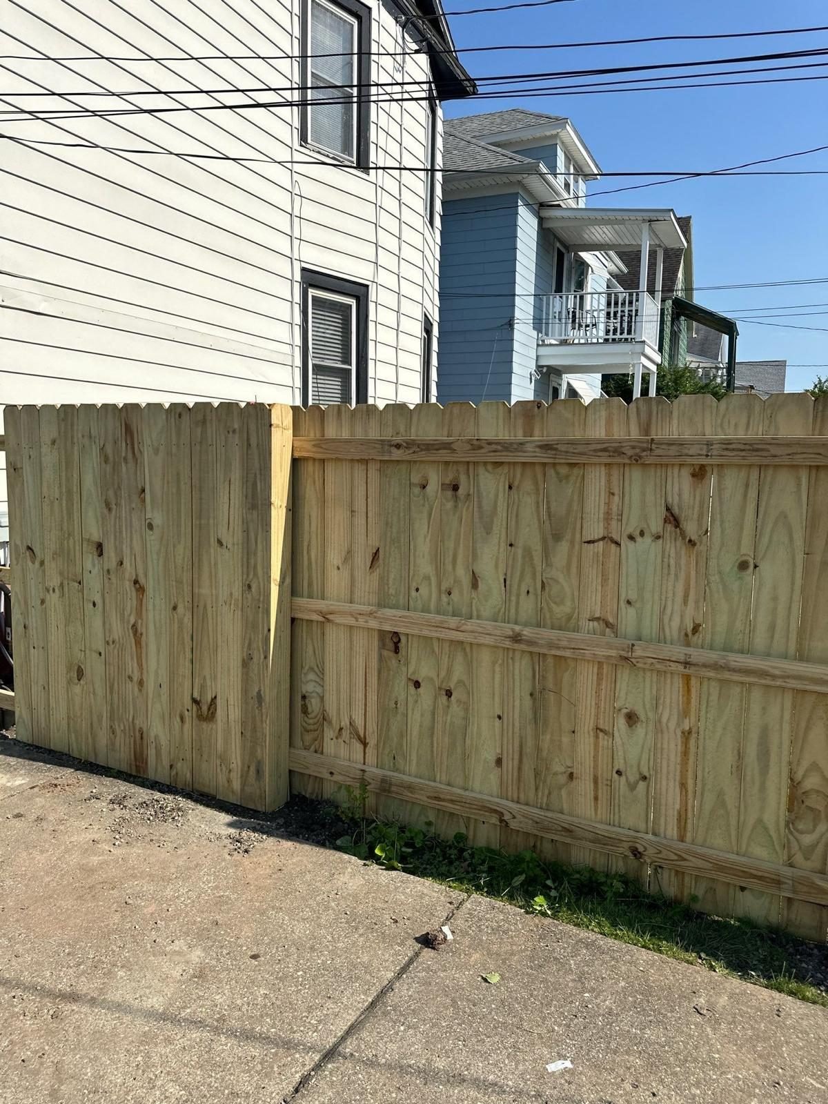 Newly installed wood fence beside a two story Buffalo home