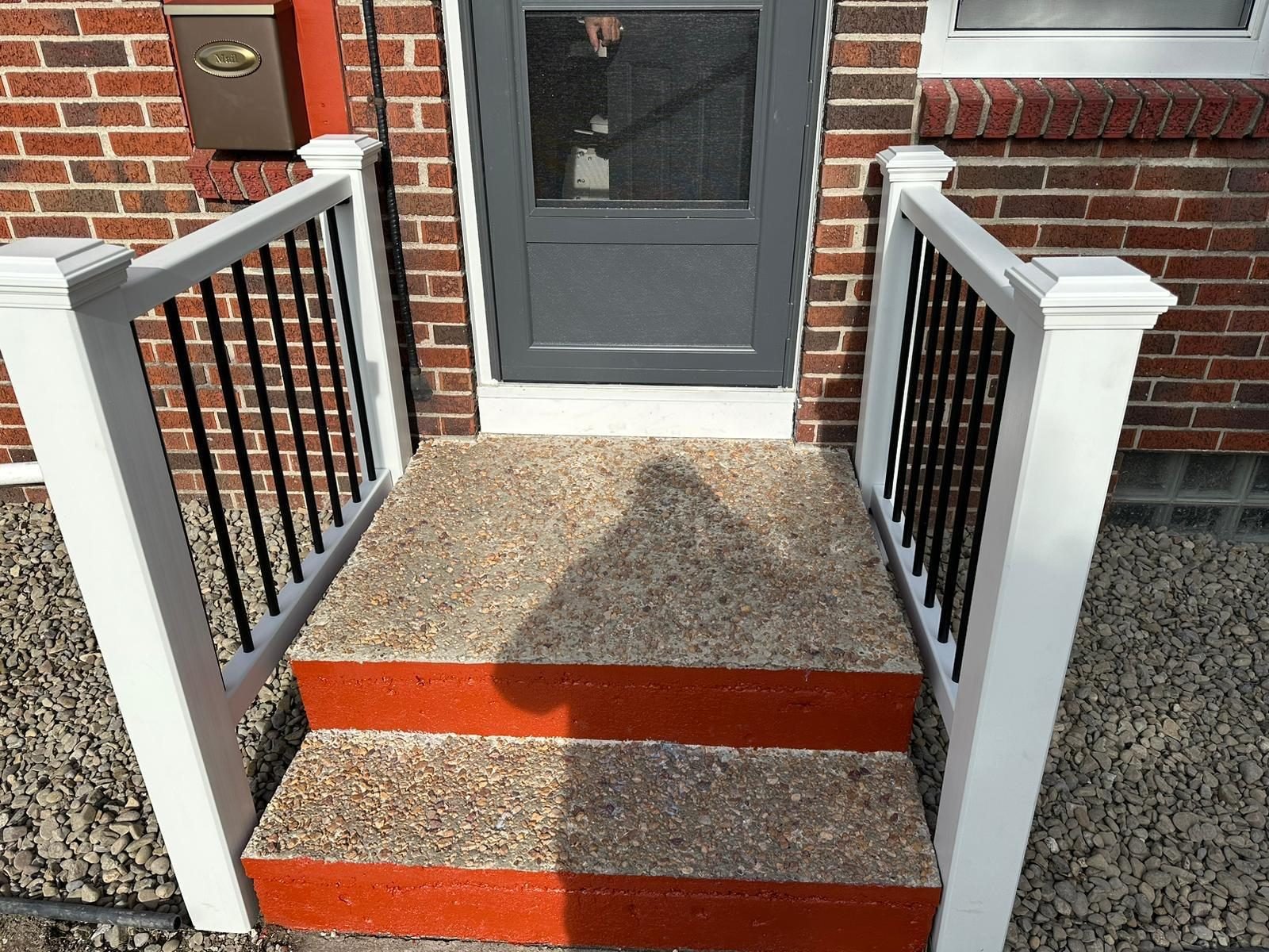 Porch steps finished in red stain with black railing