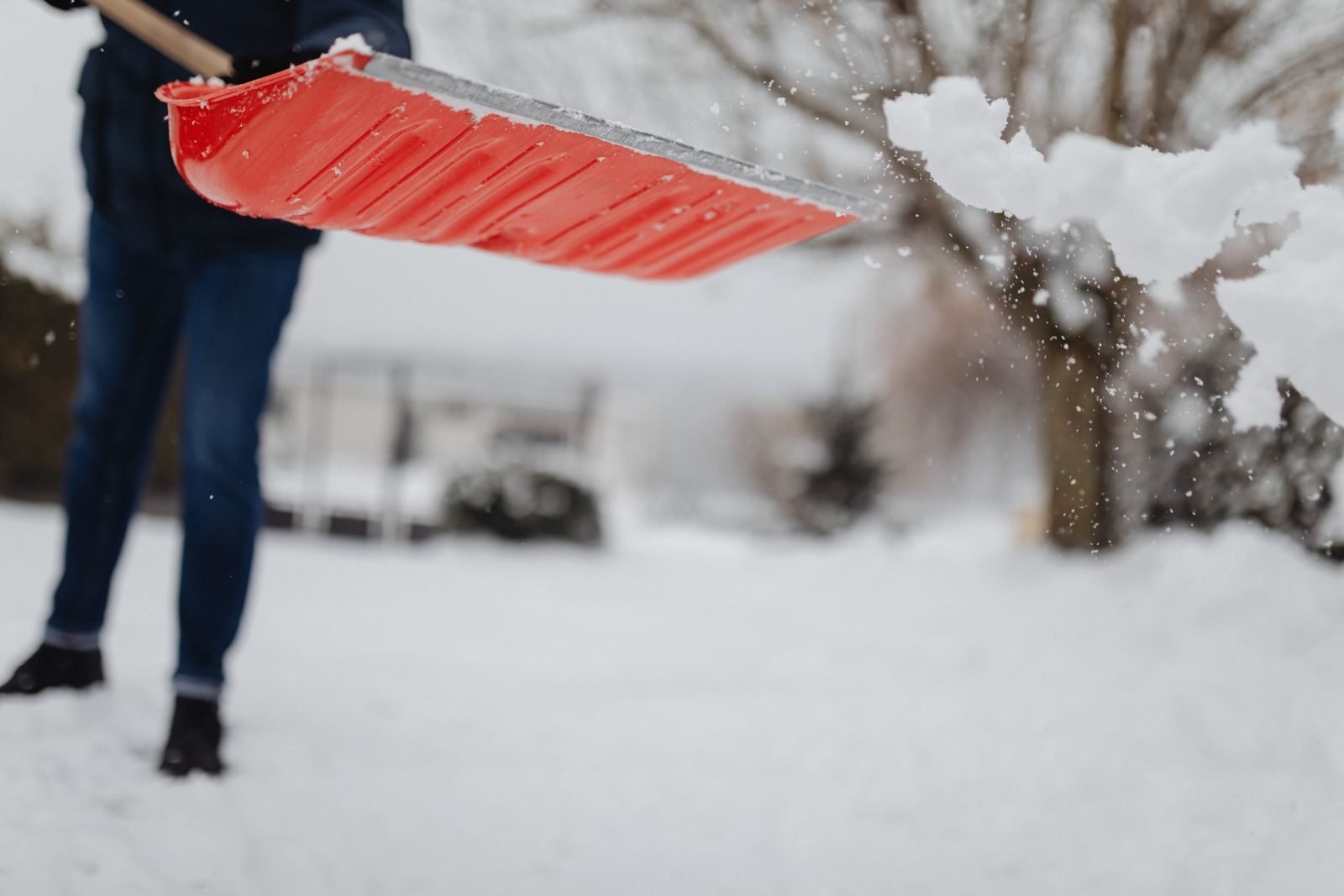 Person shoveling snow off a deck