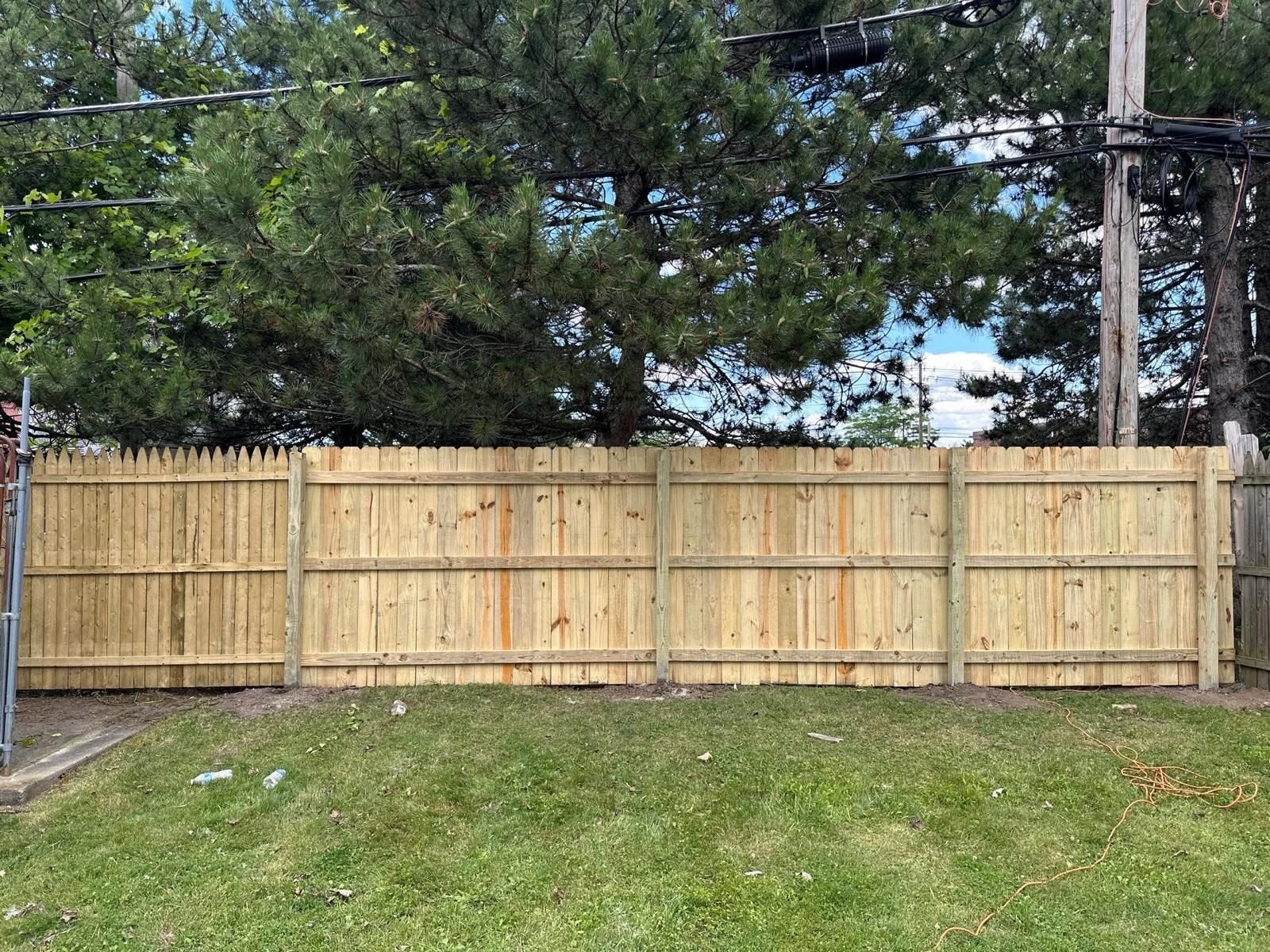 Wood privacy fence panels installed along a Western New York yard
